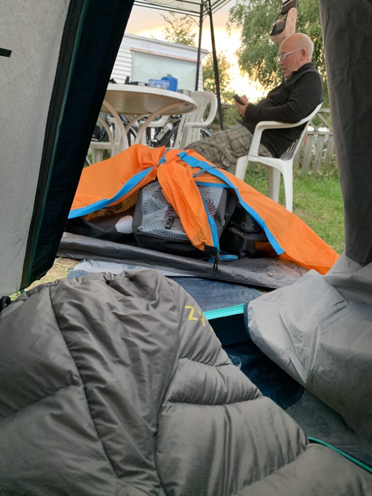 David tickert auf seinem iPhone vor unserem Zelt