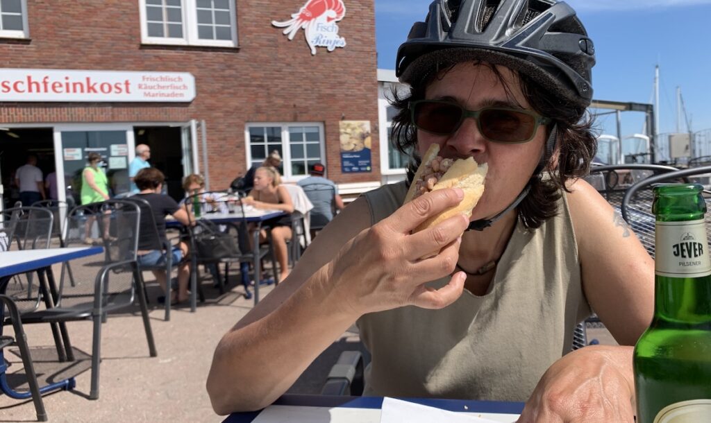 Ich beisse in ein Krabbenbroetchen am Hafen in Dornumersiel